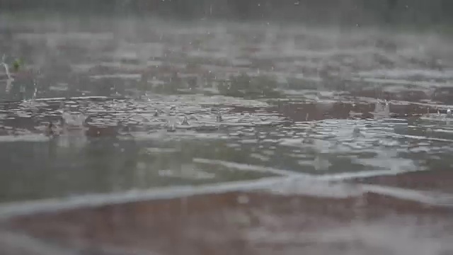 雨继续下着，铺砌着石板和水坑。视频素材