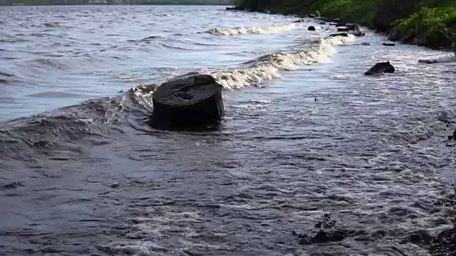 波浪冲刷着水库岸边的圆木。视频素材