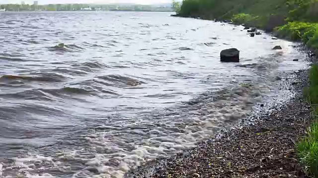 波浪冲刷着水库岸边的圆木。视频素材