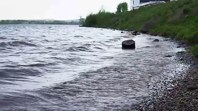 波浪冲刷着水库岸边的圆木。视频素材