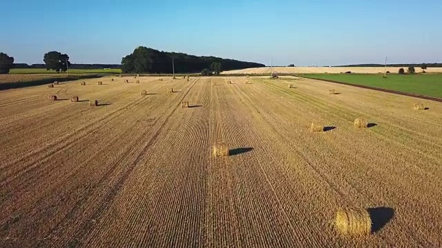 带着稻草捆的汽车经过收割过的田地视频素材