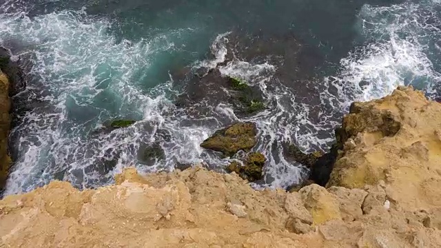 海浪溅起石壁顶视图。海浪拍打着岩石的海角视频素材