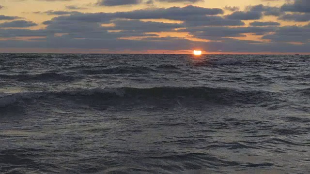 美丽的日落在海滩上，惊人的颜色，光束透过云景在海景。海上日落。日出在海滩。日落海滩。在海上日落。海上日出。慢动作视频素材