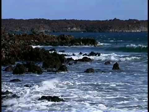 海浪冲击着夏威夷毛伊岛马凯纳海滩的岩石海岸线。视频素材