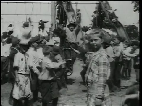 1918年，美国纽约布鲁克林，孩子们在操场上奔跑，沿着小溪滑下滑梯视频素材