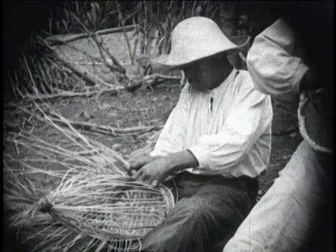 1930年，墨西哥墨西哥城，蒙太奇男人和孩子坐在稻草上编织篮子视频素材