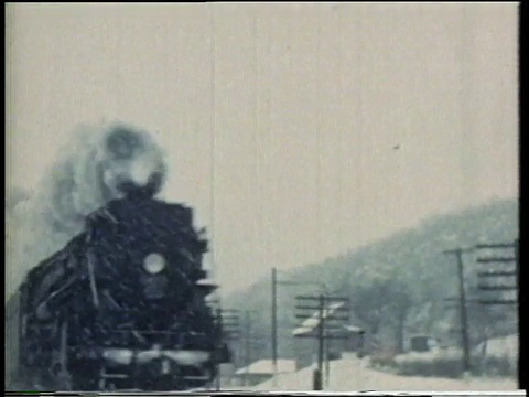 1941年，蒙太奇火车在轨道上疾驰，将雪吹向空中，发出哨声/美国视频素材