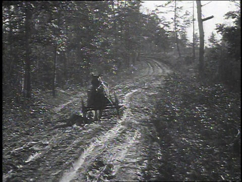 1925年，美国人试图驾驶马车在泥泞的道路上行驶，但遇到了困难视频素材