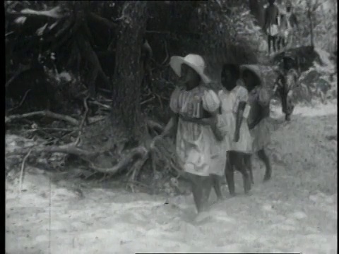 1940蒙太奇孩子们在树林里散步，手里拿着书/美国视频素材