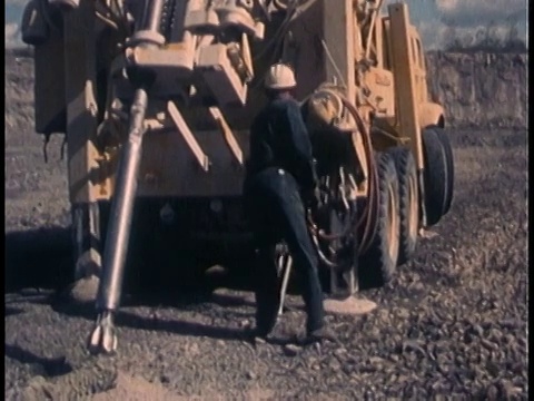 1960年代蒙太奇男子戴安全帽在道路施工车辆旁工作，滑倒并抓住他的背部/美国视频素材