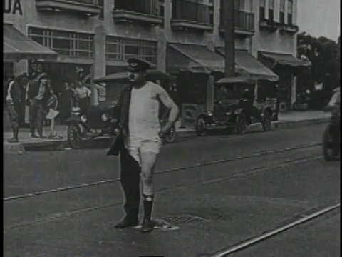 1920年蒙太奇骑摩托车的人在街道上追赶恶棍的汽车视频素材