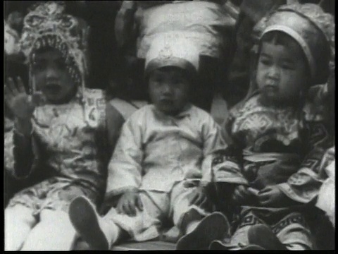 1932年PAN儿童和婴儿们穿着华丽的衣服和头饰站成一排/中国视频素材