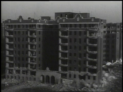 1941年，蒙太奇用人推引爆装置拆除建筑物，然后建筑物爆炸并在烟尘中坠落到地面/美国华盛顿特区视频素材