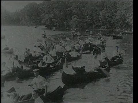 1904年7月21日，美国马萨诸塞州波士顿，人们在查尔斯河划着50只独木舟视频素材