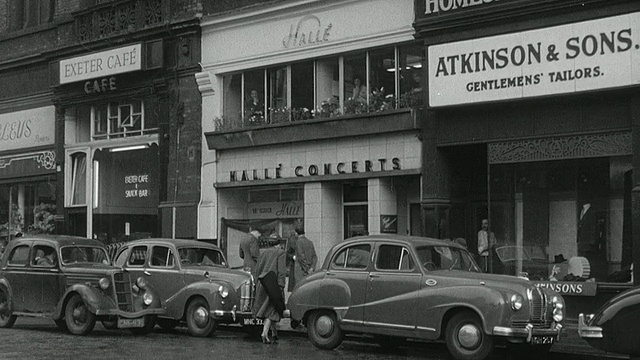 1956年，蒙太奇行人拿着小提琴盒穿过被雨水浸湿的街道，从战争纪念碑到音乐厅/英国视频素材