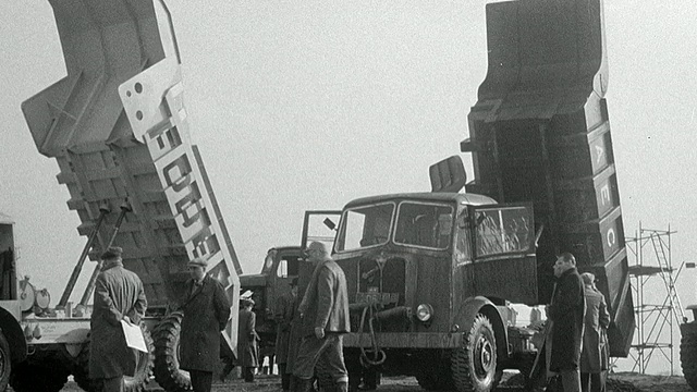 1954年蒙太奇自卸卡车和床最大程度地提高了在泥土领域，专家分散在卡车交谈/英国视频素材