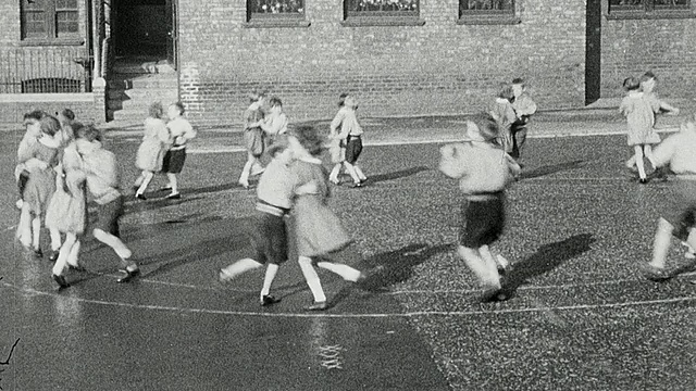 1925年，英国泰恩河畔的纽卡斯尔，一群小学男孩和女孩在操场上表演舞蹈视频素材