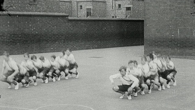 1925年，在英国泰恩河畔的纽卡斯尔，一群在操场上表演健美操的男生视频素材