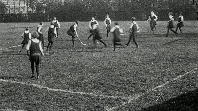 1925年，英国泰恩河纽卡斯尔中学，女学生穿着体操衣打曲棍球，男学生穿着白色打板球视频素材