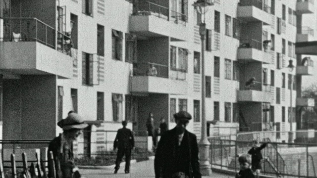 1937年，英国，北肯辛顿/伦敦，MONTAGE Kensal House出租房屋综合体，孩子们在人行道上玩耍，租户在封闭的门廊和露台上居住视频素材