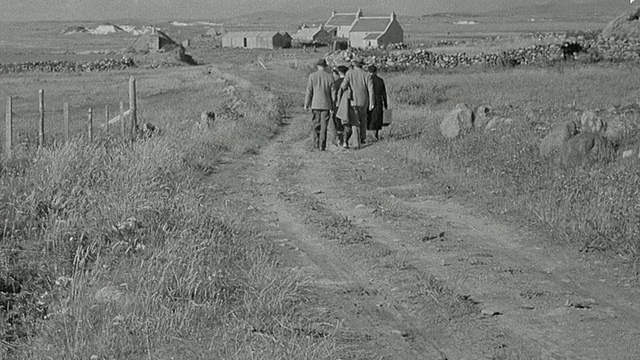 1943年蒙太奇医疗人员在家属和医生的陪同下，用担架抬着受伤病人通过开阔高地前往医院/联合王国苏格兰视频素材