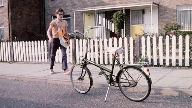 1974年，TS骑手离开他的家，骑上一辆自行车，骑在街上/英国视频素材