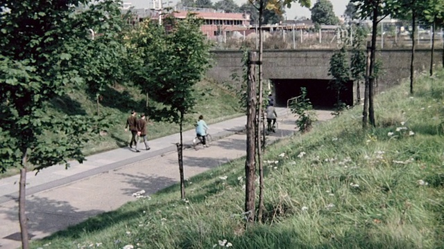 1974年，在英国，市民们骑着自行车在城市各处，在隧道下，在小径上，在自行车道的桥下视频素材