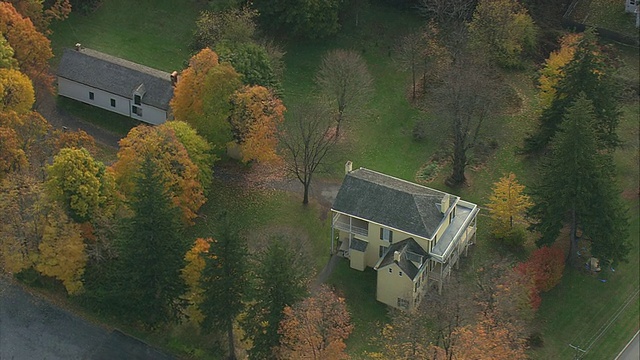 空中殖民风格的房子，在秋叶成行的街道上/ Catskill，纽约，美国视频素材