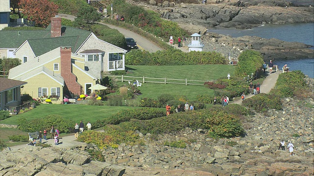 美国缅因州Ogunquit，在海边有岩石海岸线和孩子们玩耍的空中房屋和出租小屋视频下载