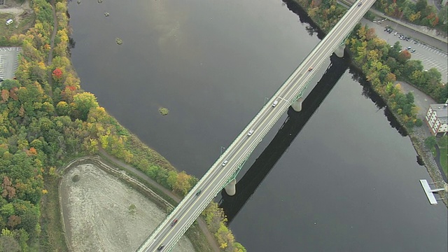 空中纪念桥横跨河流，在平静的水面上反射，和交通过桥/奥古斯塔，缅因州，美国视频素材