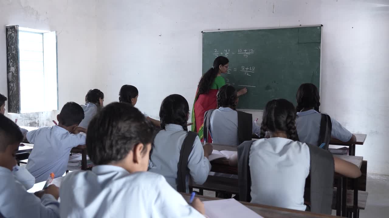 印度一名女数学老师在黑板上用粉笔写着算术，教小学生在教室里学习。印度的教育。视频素材