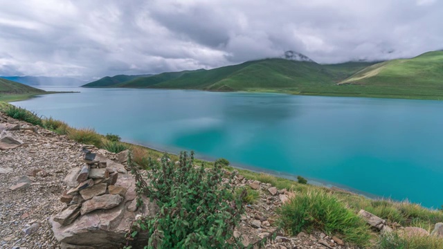 4K30P延时摄影羊卓雍措云雾下太阳光影绿色山坡湛蓝湖水视频视频素材