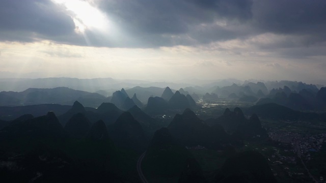 阳光透过乌云洒在群山之间的田野大地视频素材