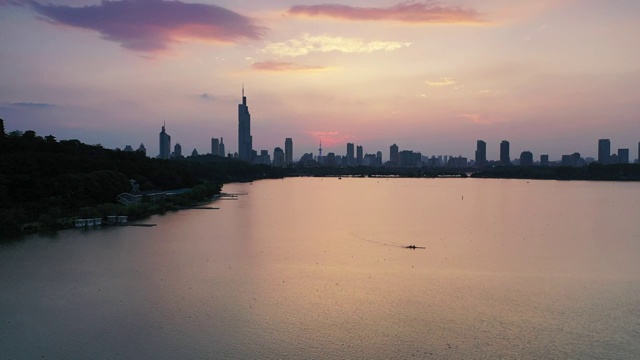 粉色的夕阳余晖下南京玄武湖湖面上的皮划艇视频素材