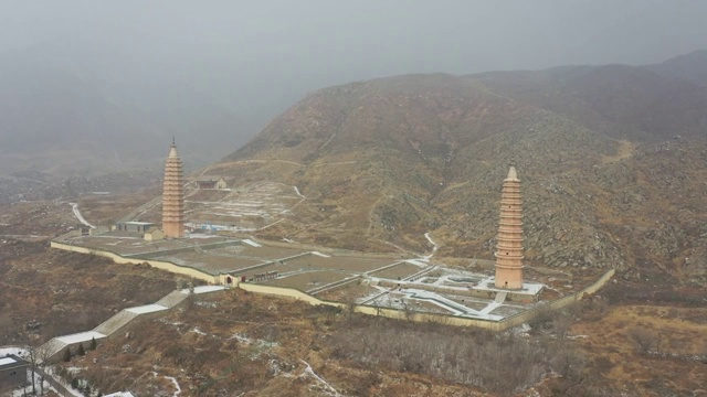 航拍雪后宁夏银川贺兰山边的拜寺口双塔视频素材