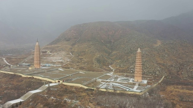 航拍雪后宁夏银川贺兰山边的拜寺口双塔视频素材