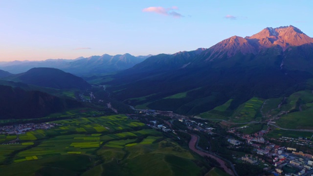 航拍清晨中国青海省海北祁连县卓尔山县城与牛心山日照金山视频素材