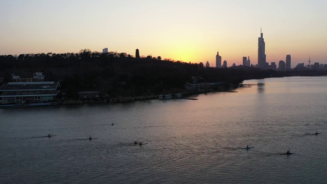 夕阳余晖下南京玄武湖湖面上的正在进行训练的皮划艇运动员视频素材