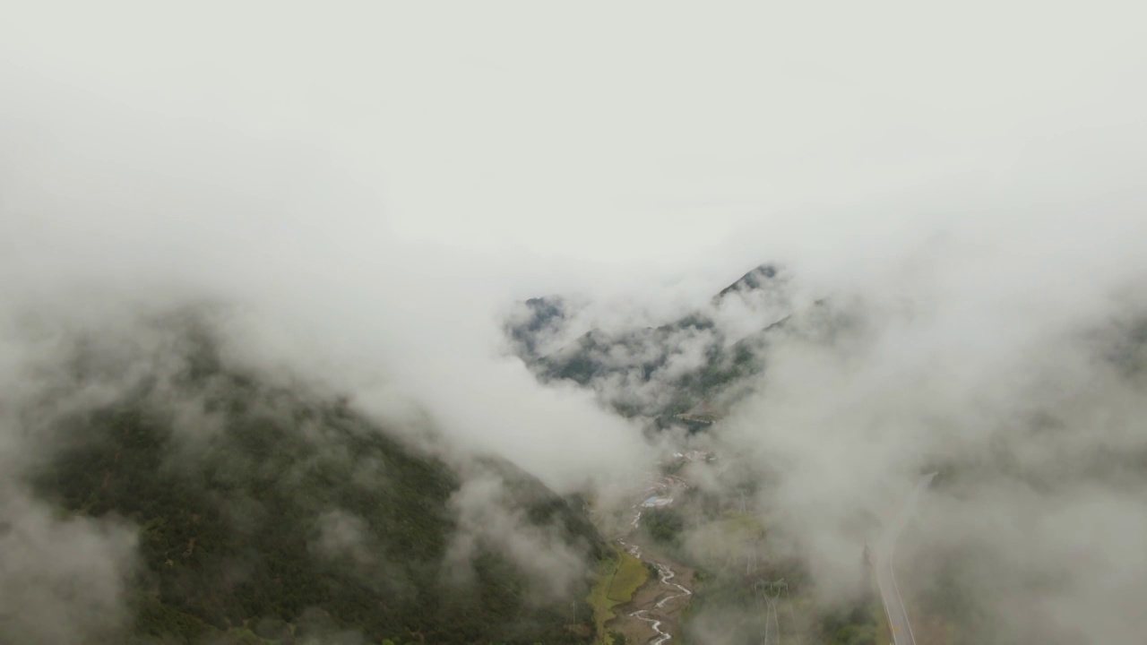 高视角航拍四川甘孜州理塘县雾中的山谷视频素材