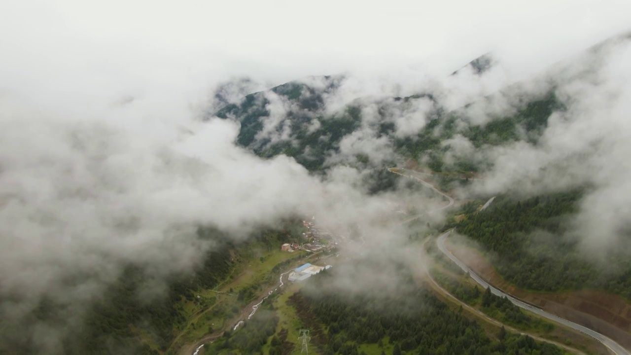 高视角航拍四川甘孜州理塘县雾中的山谷视频素材