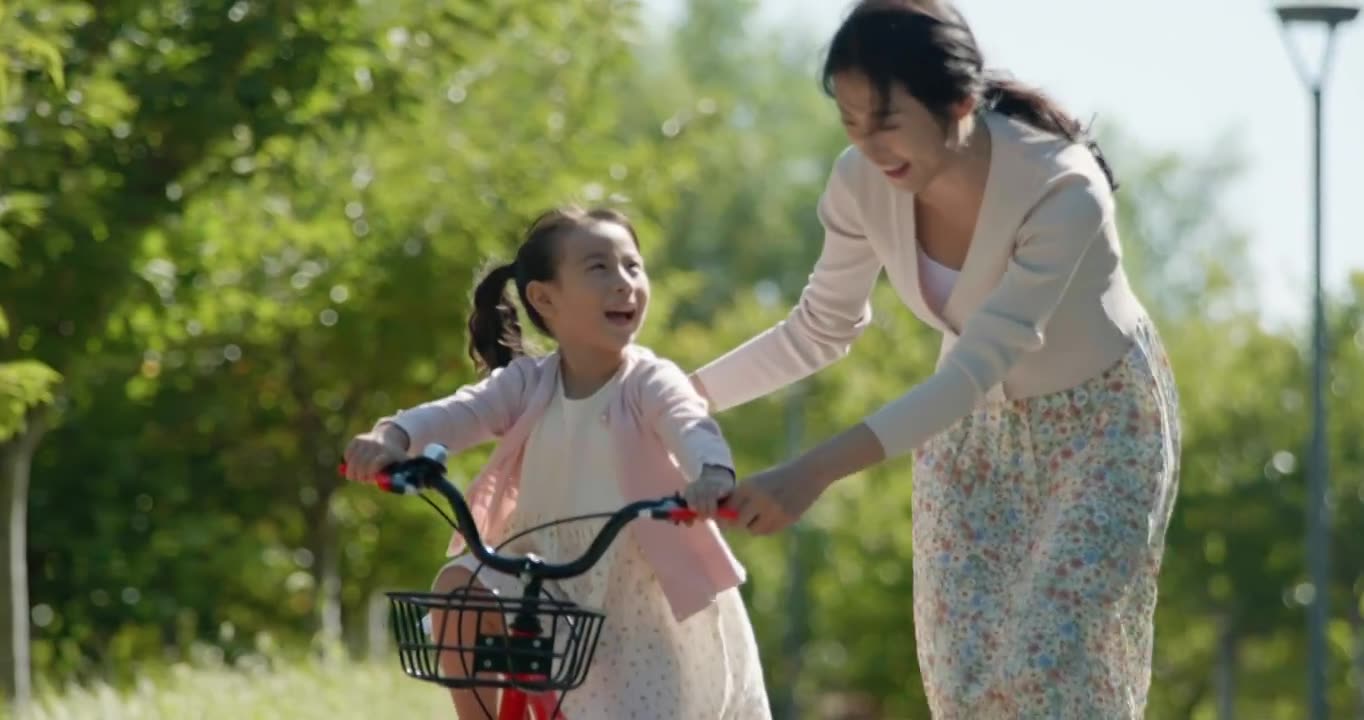 母亲教女儿骑自行车视频素材画面1