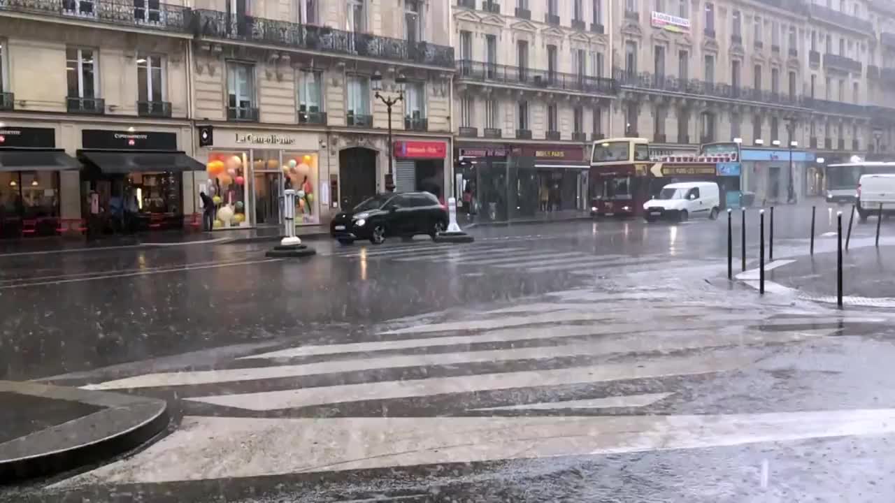 暴雨中一名行人快步跑过巴黎的街道视频素材