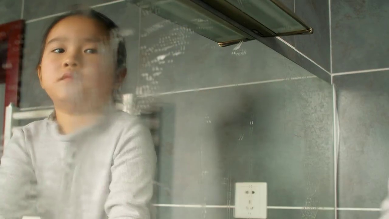 一个亚洲小女孩在家擦镜子视频素材画面2