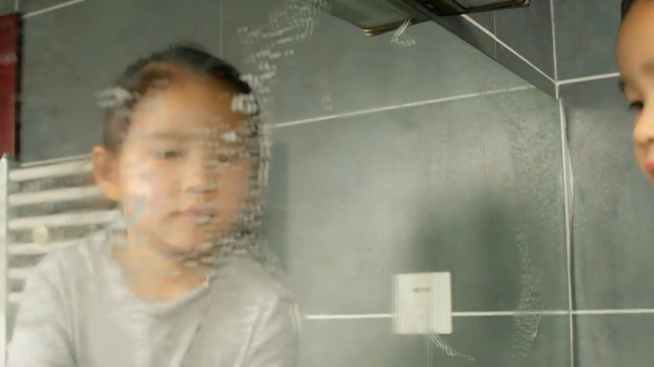 一个亚洲小女孩在家擦镜子视频素材画面3