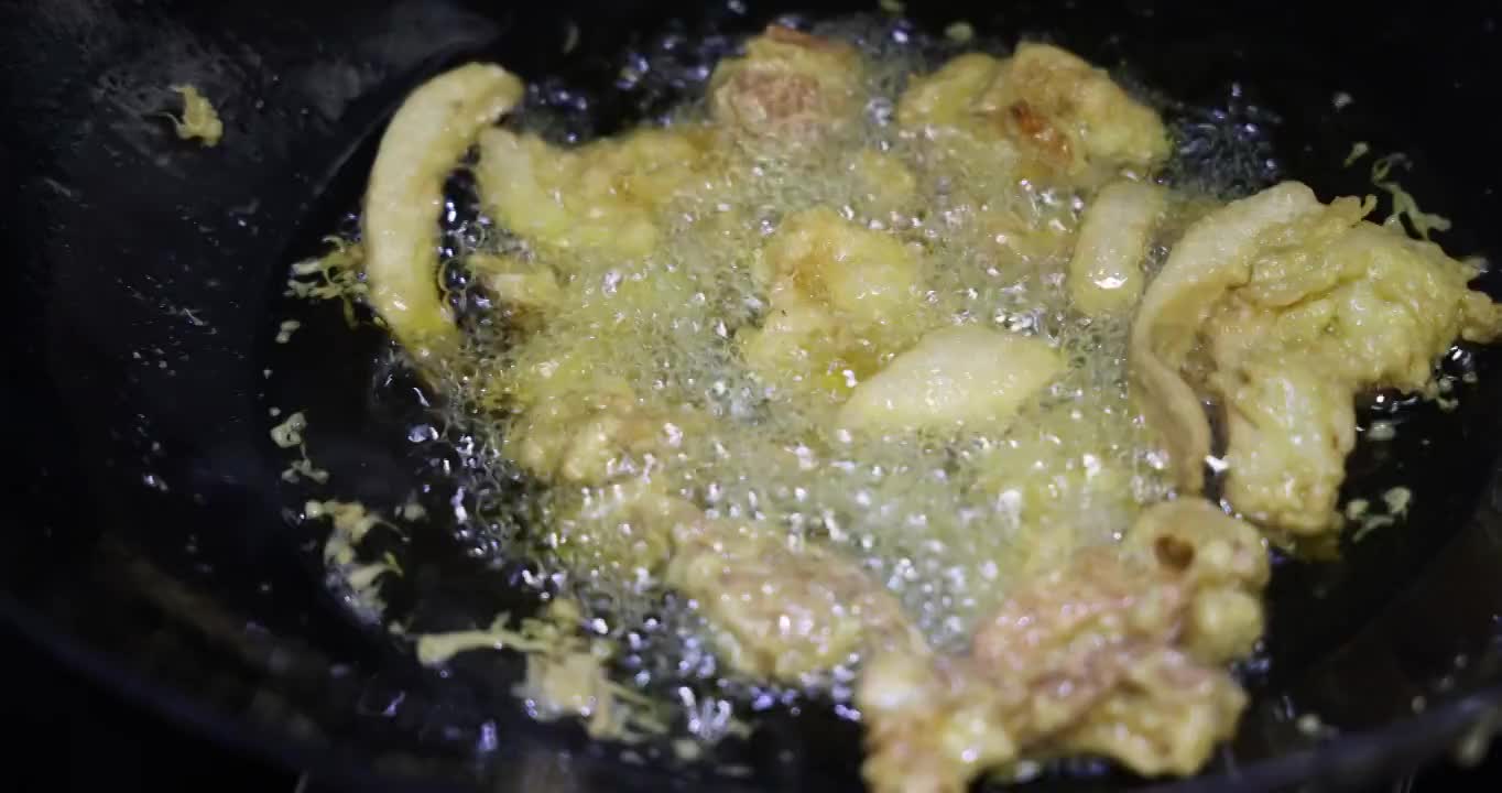 美食烹饪：使用漏勺舀出油炸完毕的酥肉视频素材