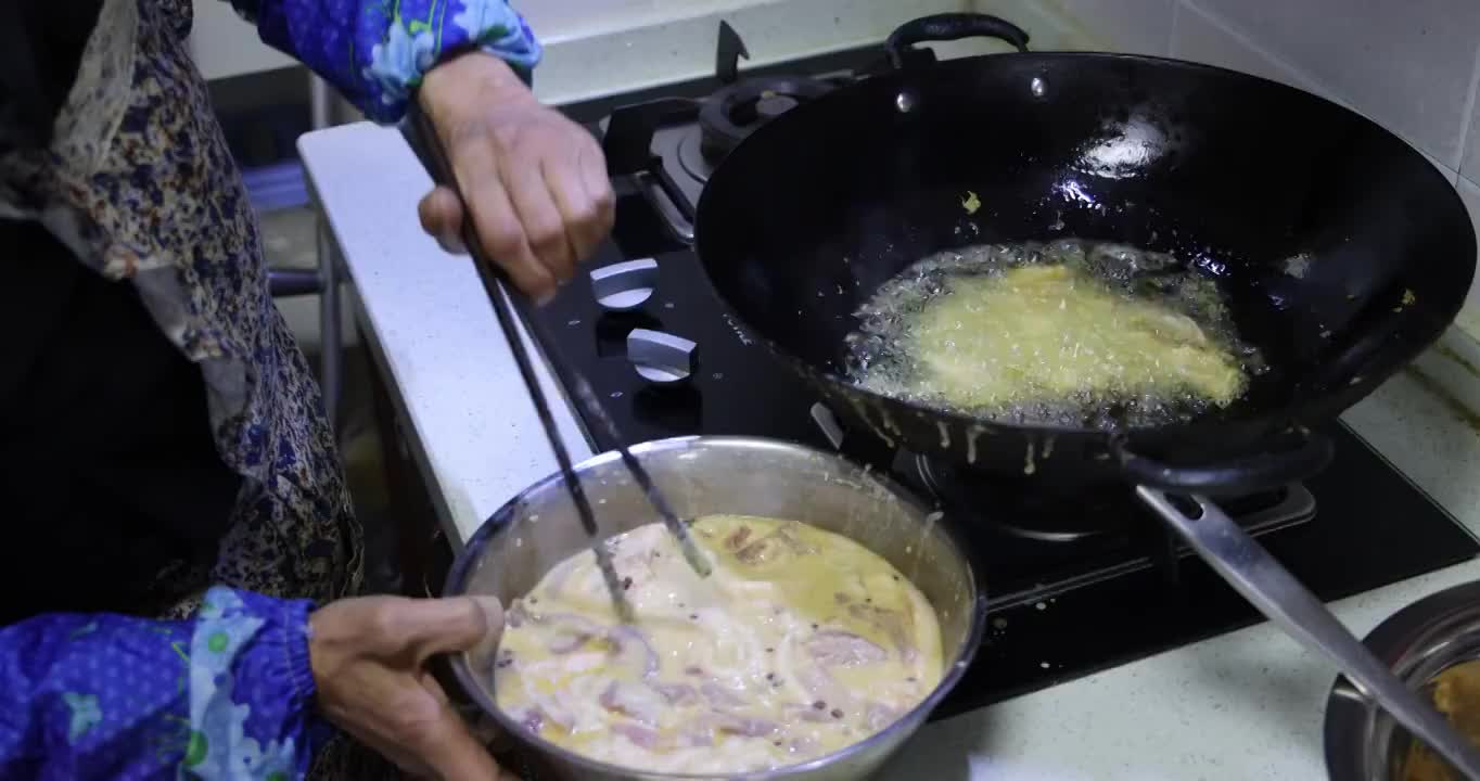 美食烹饪：裹上面糊鸡蛋的酥肉放入油锅里油炸视频素材