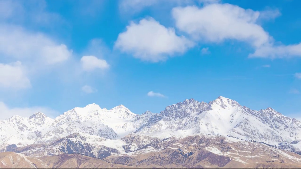 中国新疆温宿境内冬季天山山脉雪峰与蓝天白云视频素材