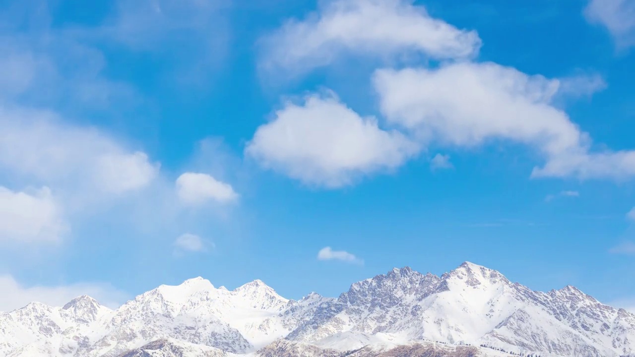 中国新疆温宿境内冬季天山山脉雪峰与蓝天白云视频素材