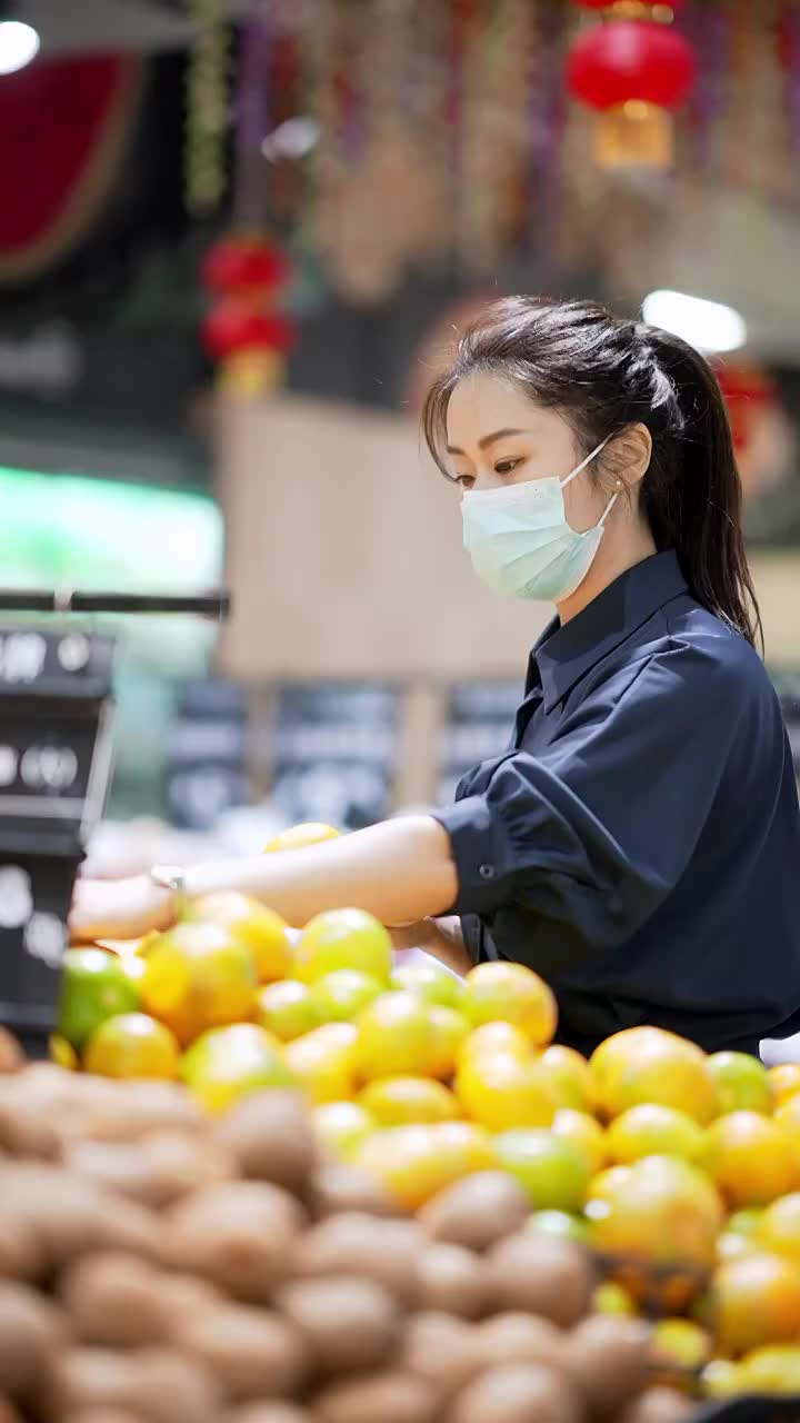 年轻女子在超市里选购水果视频素材