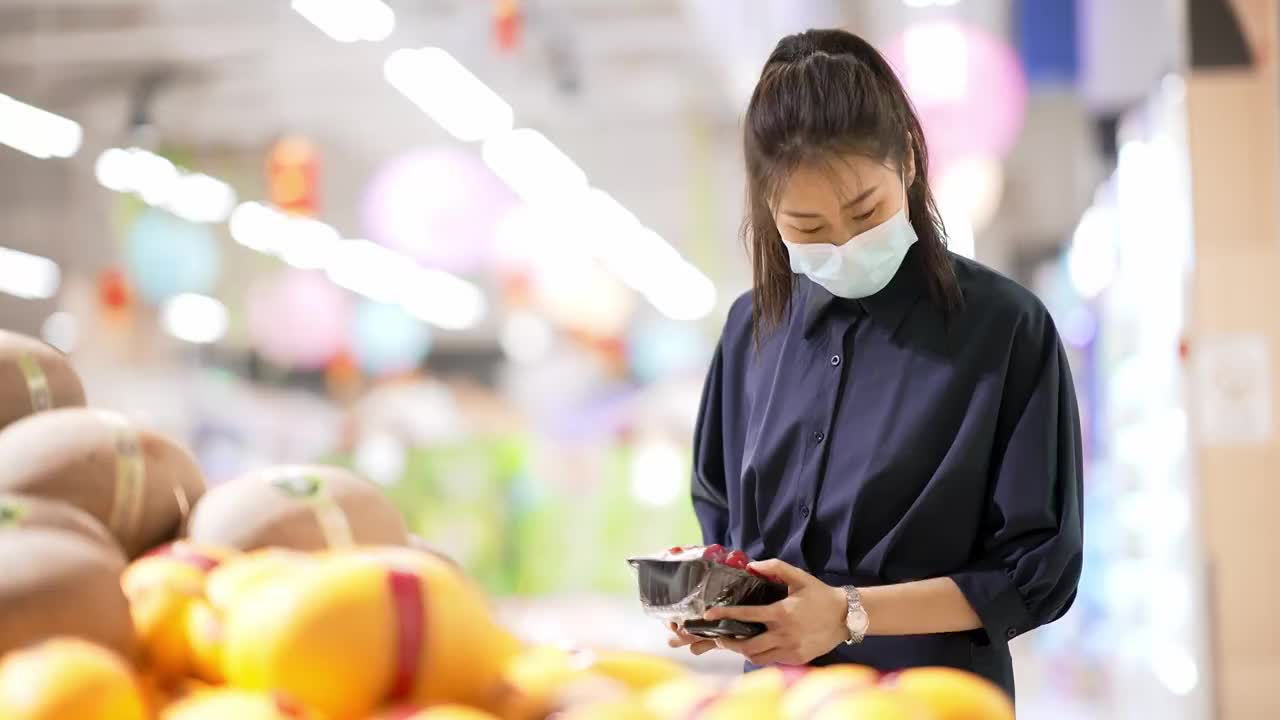 年轻女子在超市里选购水果视频素材